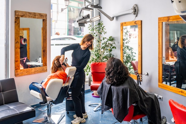 Photo un coiffeur qui s'occupe de ses clients dans un salon de coiffure