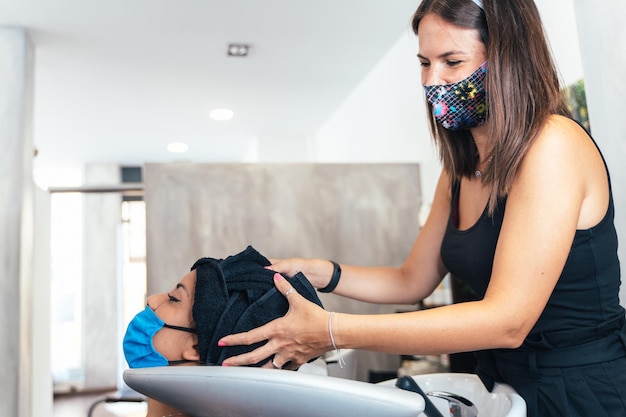 Coiffeur séchant les cheveux d'un client avec une serviette