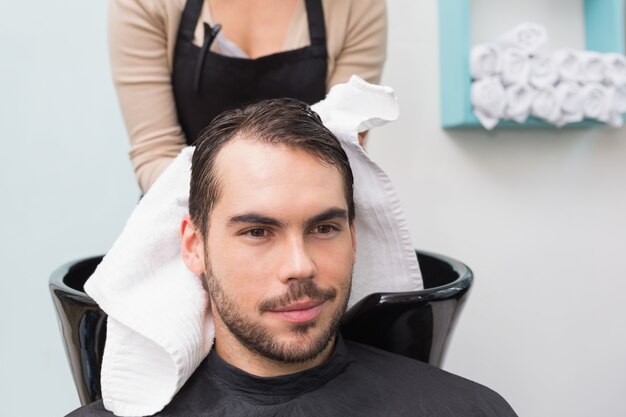 Coiffeur séchant les cheveux de mans