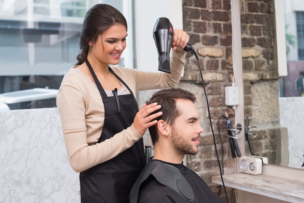 Coiffeur séchant les cheveux de mans