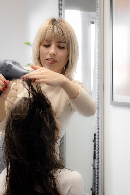 Le coiffeur sèche les cheveux d'un client