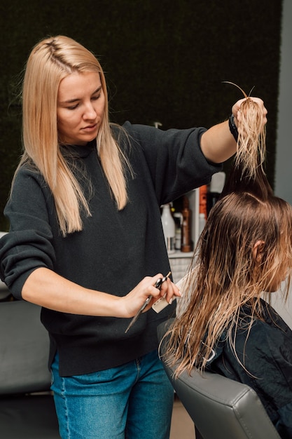 Le coiffeur a soulevé une mèche de cheveux et a coupé la longueur