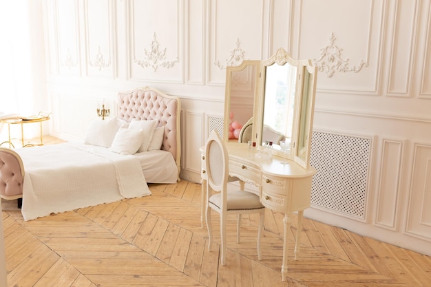 coiffeuse pour femme. table avec miroir dans la chambre. ensemble de toilette blanc près du lit