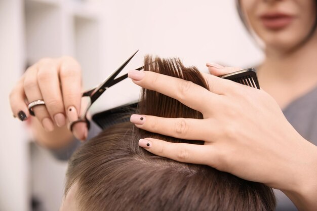 Coiffeuse professionnelle travaillant avec le client dans le salon