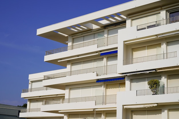 Coin de bâtiment avec de nombreuses fenêtres balcon sur ciel bleu