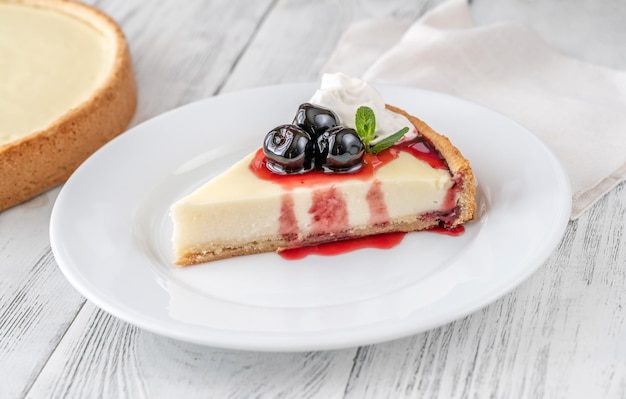 Coin de gâteau au fromage traditionnel avec des cerises amarena sur l'assiette