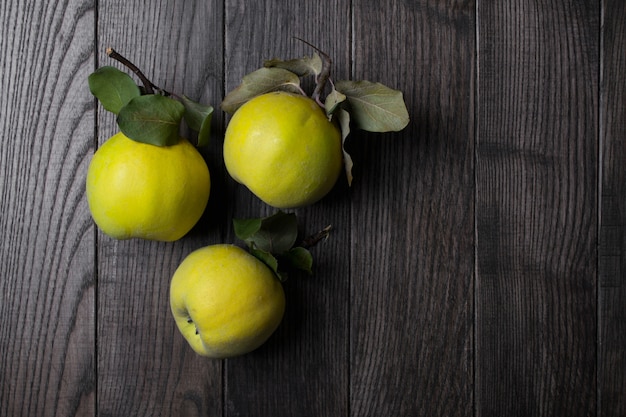 Coing sur table en bois foncé. Fruits d'automne.