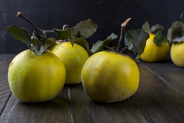 Coing sur table en bois foncé. Fruits d'automne.