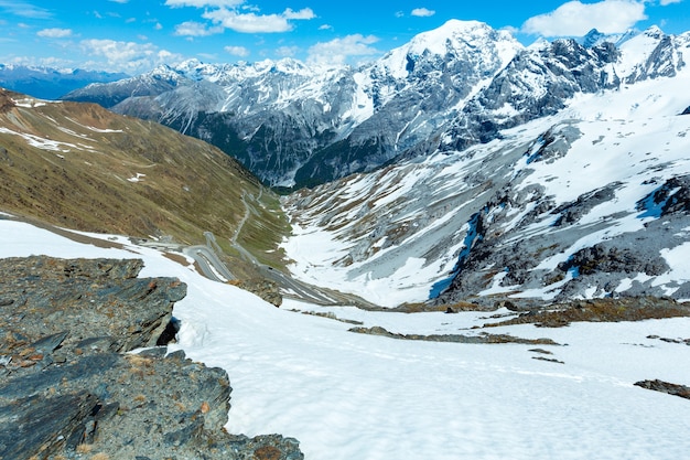 Col du Stelvio d'été avec route alpine et neige sur pente (Italie)