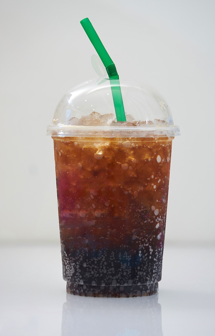 Photo cola glacé dans une tasse en plastique transparente avec paille verte sur fond blanc avec ombre