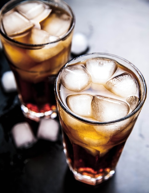 Cola avec de la glace sur une table en bois. boissons non alcoolisées