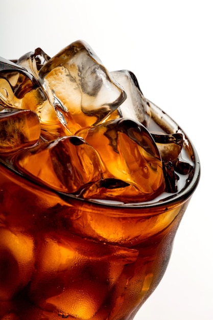 Cola avec des glaçons en gros plan de verre