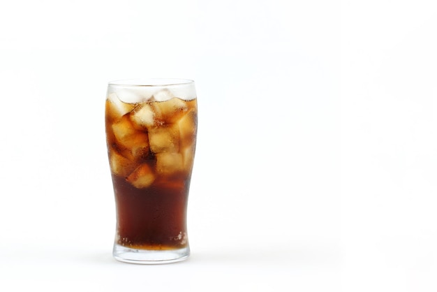 Cola en verre avec de la glace sur fond blanc.