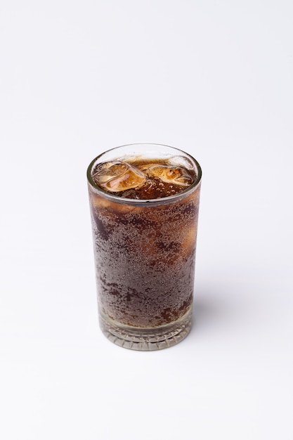 Cola en verre avec des glaçons clairs isolés sur fond blanc