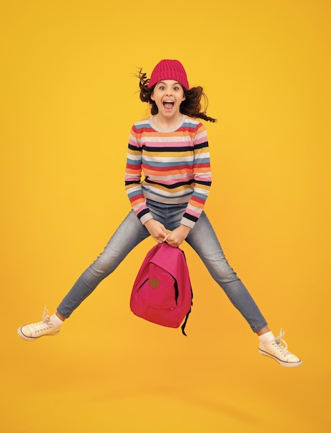 École d'automne Adolescent écolière avec sac à dos en vêtements d'automne sur studio isolé jaune