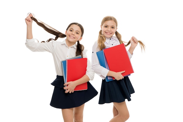 École privée. Nous aimons étudier. Étudier est amusant. Acheter un livre pour un cours extrascolaire. Les élèves transportent des manuels dans les classes de l'école. Cours de langue pour les jeunes. Filles avec fond blanc de manuels scolaires.