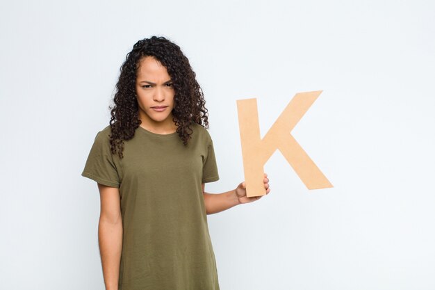 en colère, colère, désaccord, tenant la lettre K de l'alphabet pour former un mot ou une phrase.