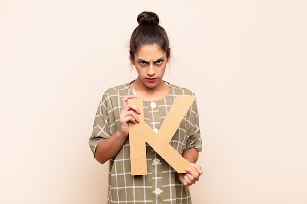 en colère, colère, désaccord, tenant la lettre K de l'alphabet pour former un mot ou une phrase.