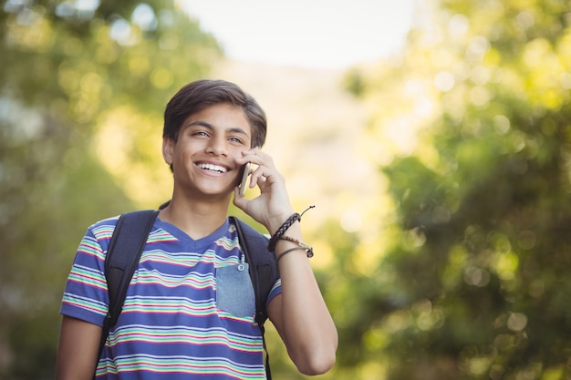 Écolier à l'aide de téléphone mobile sur le campus à l'école