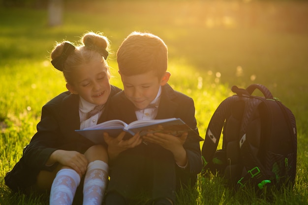 Écolier et écolière lisant un livre