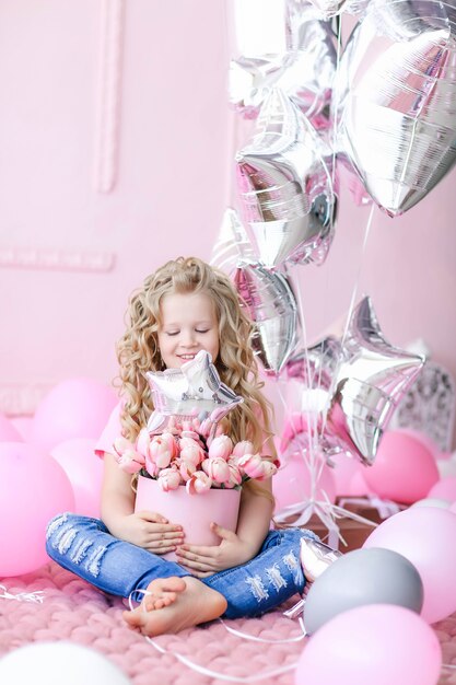 Écolier fille assise avec panier rose avec des fleurs.