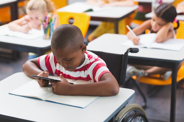 Écolier handicapé à l'aide de tablette numérique