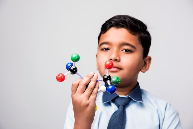 Écolier indien ou étudiant en sciences utilisant un kit de modèle moléculaire pour étudier la physique, mise au point sélective