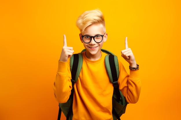 Écolier en lunettes avec sac à dos prêt à aller à l'école pour l'éducation pointant vers le haut avec l'index