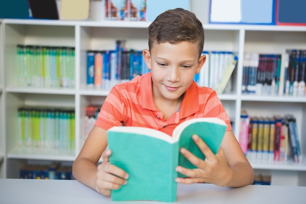 Écolier, séance table, et, livre lecture, dans, bibliothèque