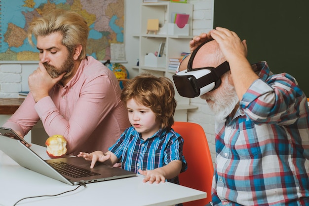 Écolier de technologie de l'éducation étudiant les devoirs à la maison père grand-père et fils enfant ensemble