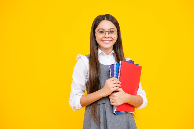 Écolière adolescente avec des livres fond de studio isolé