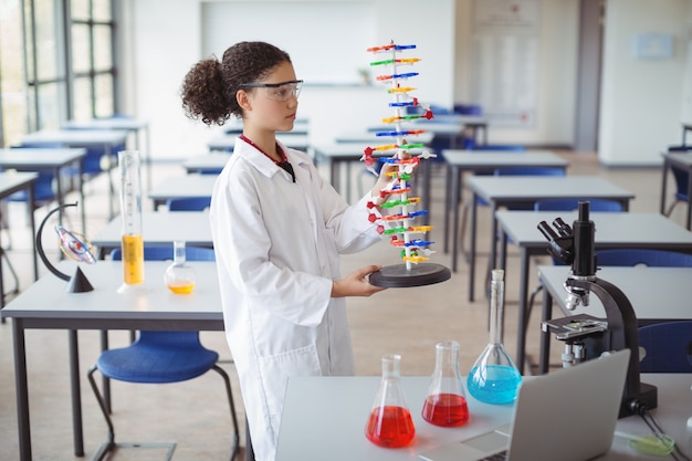 Écolière attentive expérimentant le modèle de molécule en laboratoire