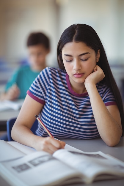 Écolière attentive qui étudie en classe