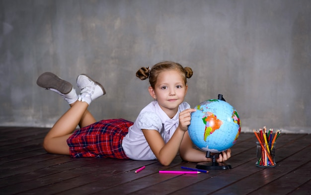 Écolière aux couleurs et globe terrestre. concept d'école