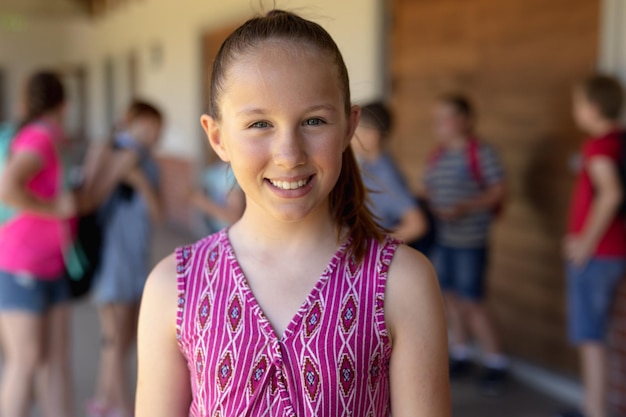 Écolière debout dans la cour de l'école primaire