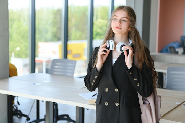 Écolière debout avec des livres et sac à dos à l'école