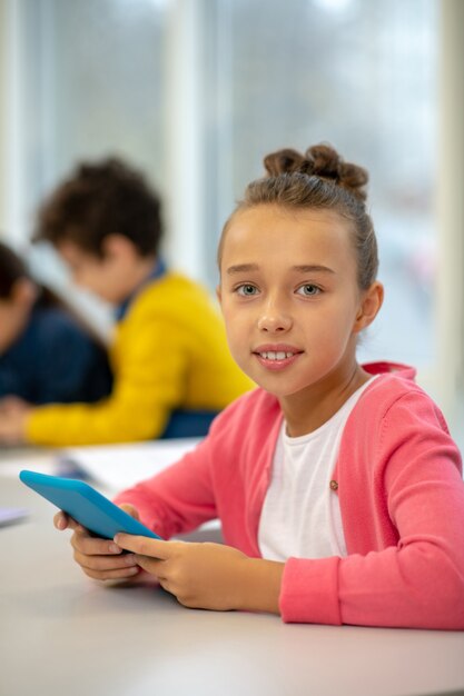 Écolière étant sérieux en regardant l'écran de la tablette