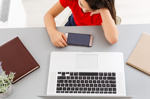 Écolière étudiant à la maison à l'aide d'un ordinateur portable. École à domicile, éducation en ligne, éducation à domicile, concept de quarantaine - Image