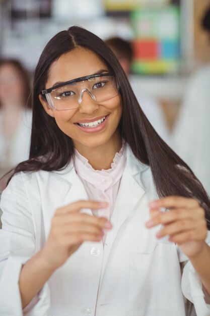 Écolière expérimentant avec un morceau de verre en laboratoire à l'école