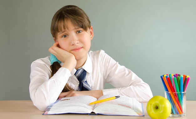 Écolière fille assise en classe à un bureau