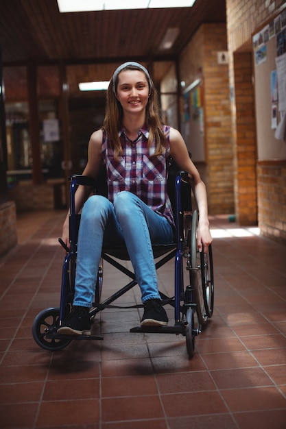 Écolière handicapée en fauteuil roulant dans le couloir à l'école