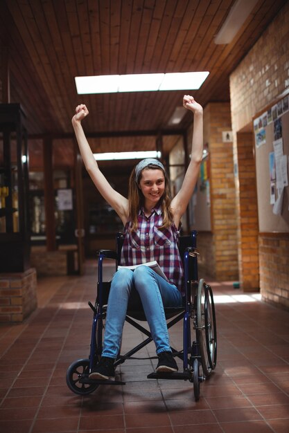 Écolière handicapée en fauteuil roulant dans le couloir à l'école