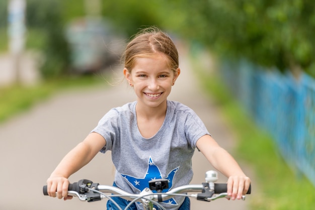 Écolière joyeuse à vélo à l'extérieur