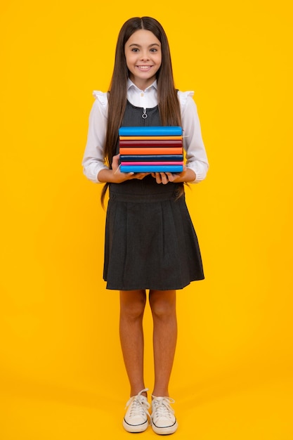 Écolière avec livre de copie posant sur fond isolé Leçon de littérature grammar school Lecteur enfant intellectuel