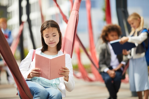 Écolière avec livre en plein air