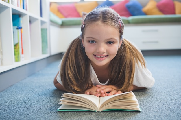 Écolière, mensonge plancher, et, lecture livre, dans, bibliothèque