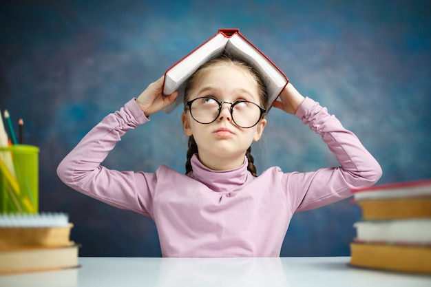 Écolière mignonne crier la tête avec un livre ouvert