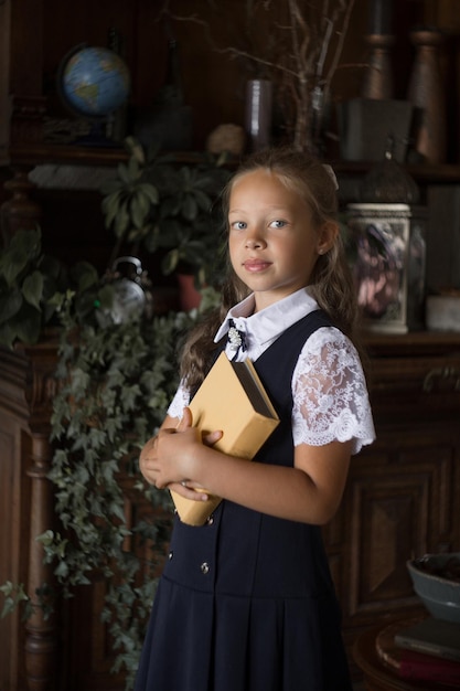 Écolière primaire en uniforme scolaire avec un livre