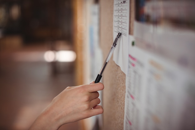 Écolière à la recherche de tableau d'affichage dans le couloir