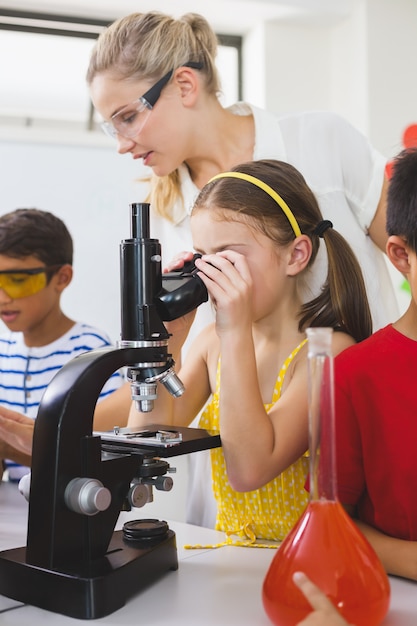 Écolière, regarder, par, microscope, laboratoire